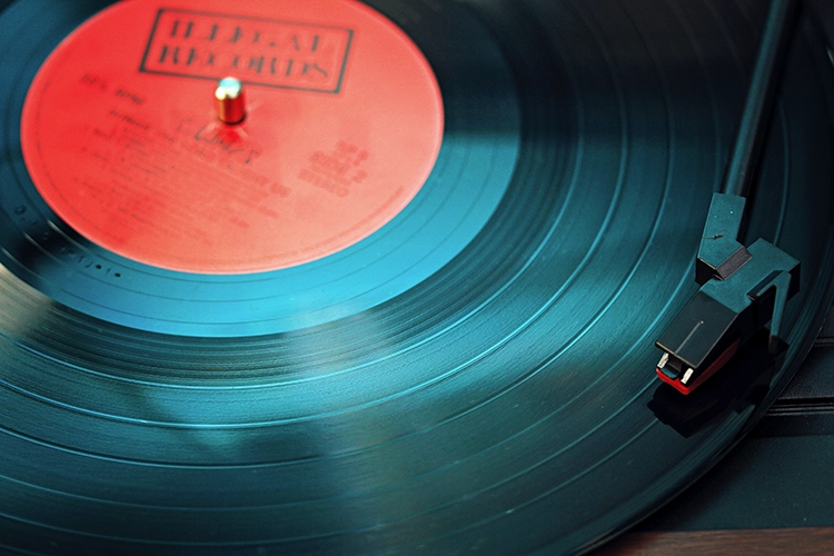 Photo d'illustration en gros plan mettant en avant le bras de lecture d'un tourne-disque placé sur un vinyle